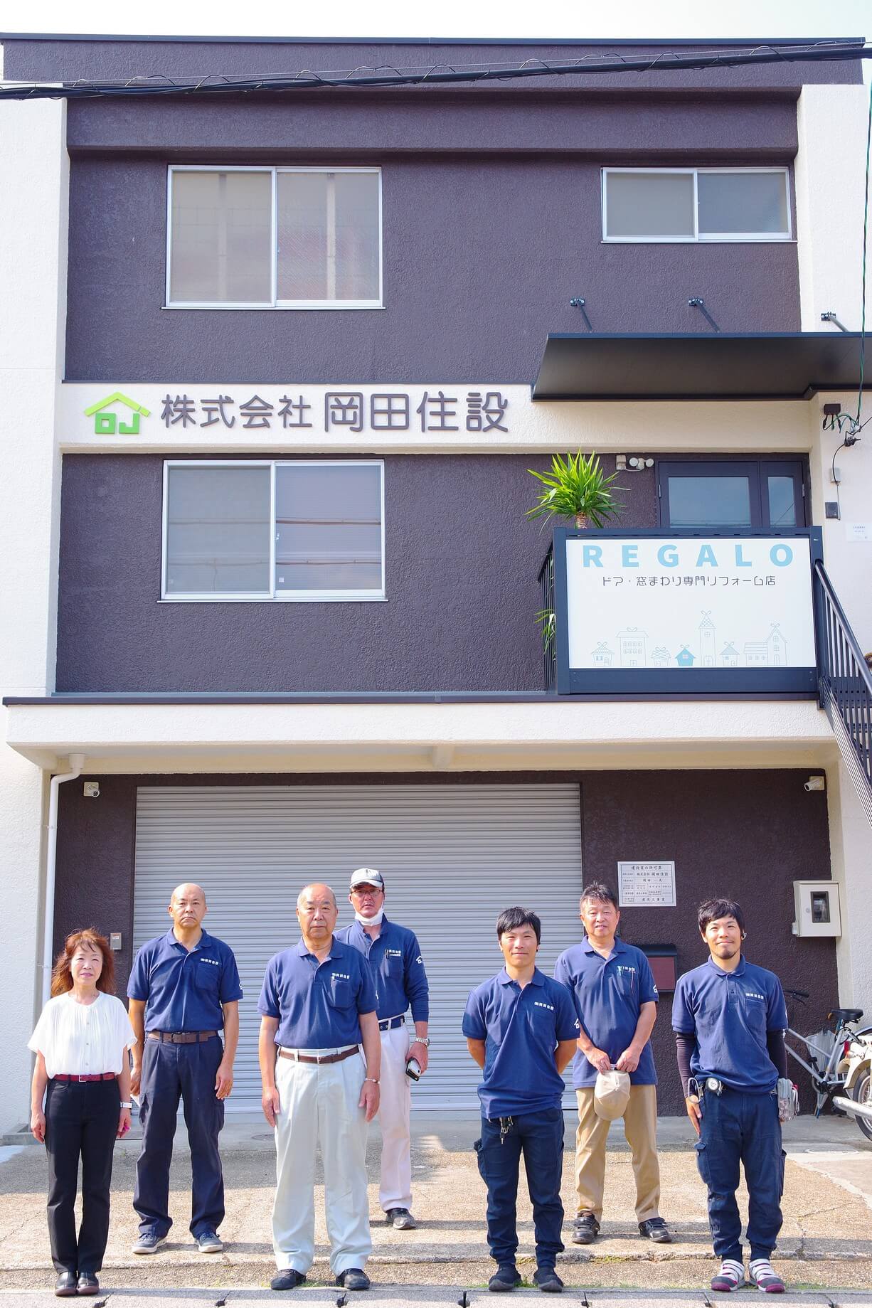 会社の前でスタッフの全員写真